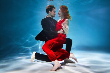 Genç bir adam ve bir kız havuzda poz veriyorlar. Avrupalı çift havuzda yüzüyor