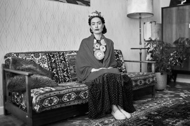 İçeride poz veren ünlü sanatçı Frida Kahlo 'nun suretindeki genç ve güzel kadın. Siyah beyaz fotoğraf.