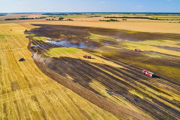 Rescuers extinguish a small fire in the field