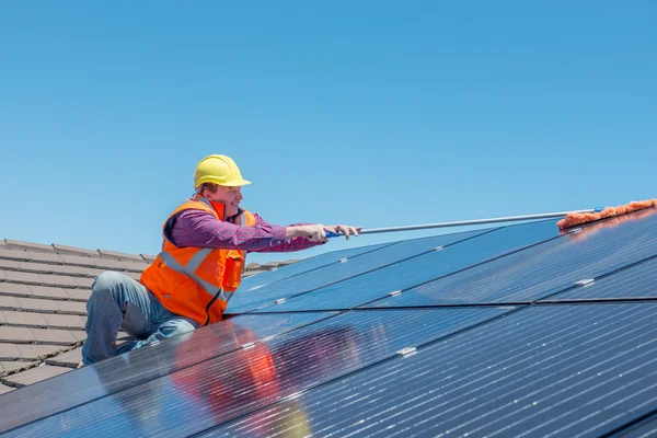 Werknemer en zonnepanelen Rechtenvrije Stockfoto's