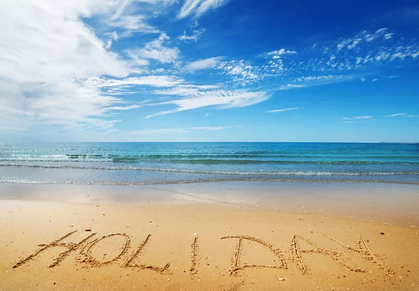 Urlaubsbotschaft im Sand — Stockfoto