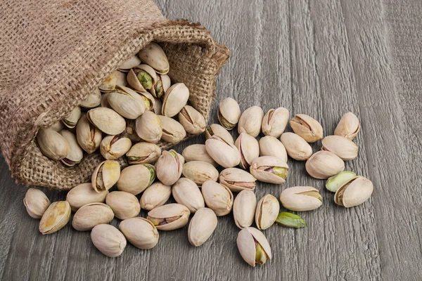 Pistachios on wooden table — Stock Photo, Image