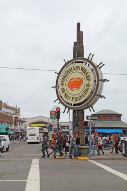 Tourists and sign for Fishermans Wharf in San Francisco clipart