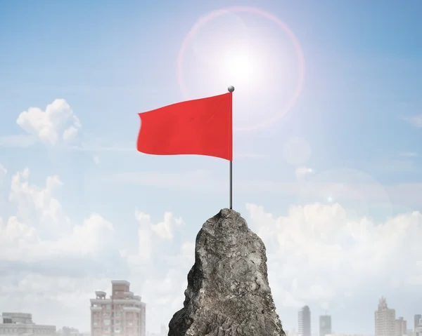 Bandera ondulada roja en la cima del pico rocoso de la montaña —  Fotos de Stock