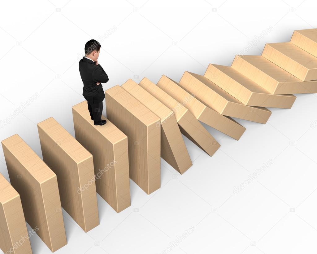 Man standing and thinking on falling wooden dominoes