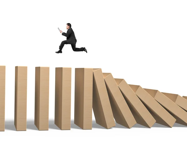 Man using tablet running on falling wooden dominoes — Stock Photo, Image