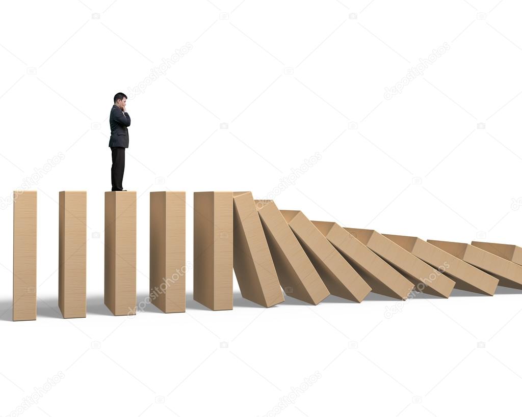 Man standing and thinking on falling wooden dominoes