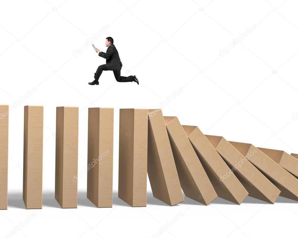Man using tablet running on falling wooden dominoes