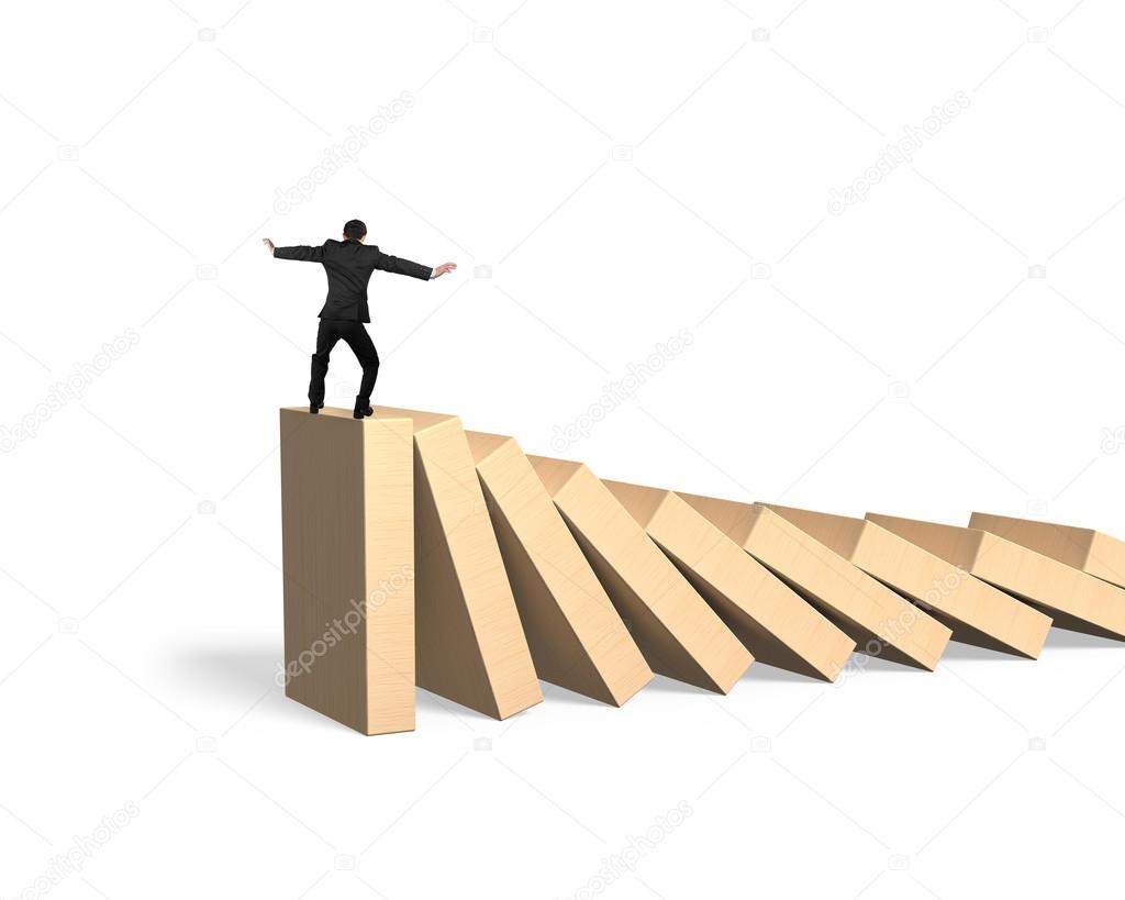 Man standing and balancing on domino