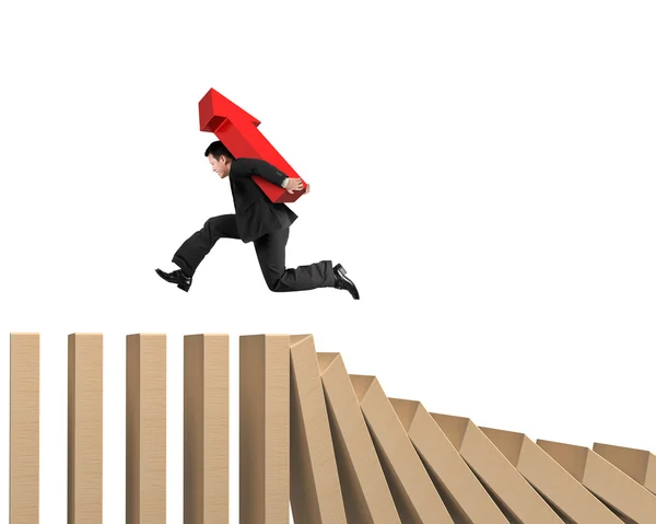 Man carrying arrow up running on falling wooden dominos — Stock Photo, Image