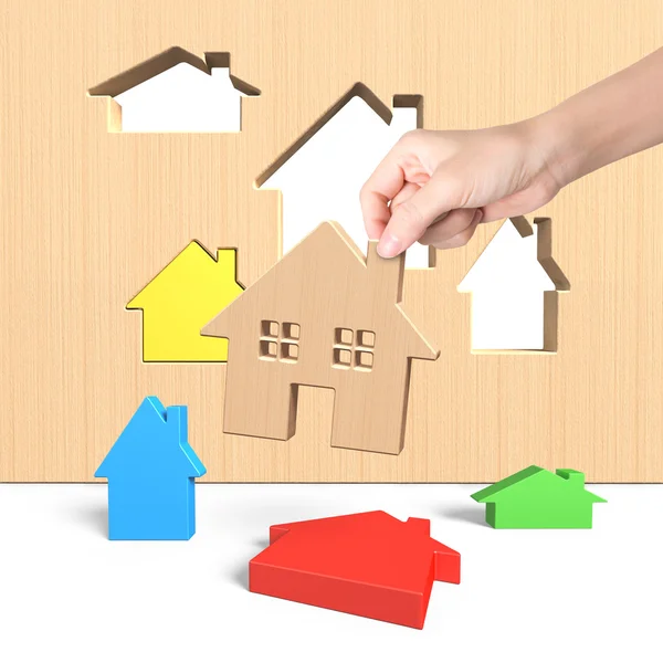 Woman hand picking wooden house — Stock Photo, Image