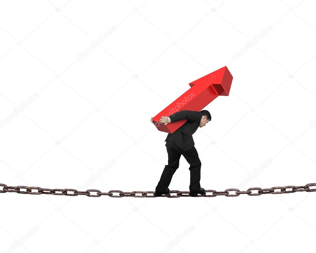 Businessman carrying red arrow sign balancing on chain