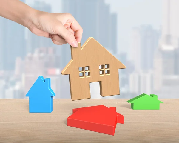 Vrouw hand plukken houten huis — Stockfoto