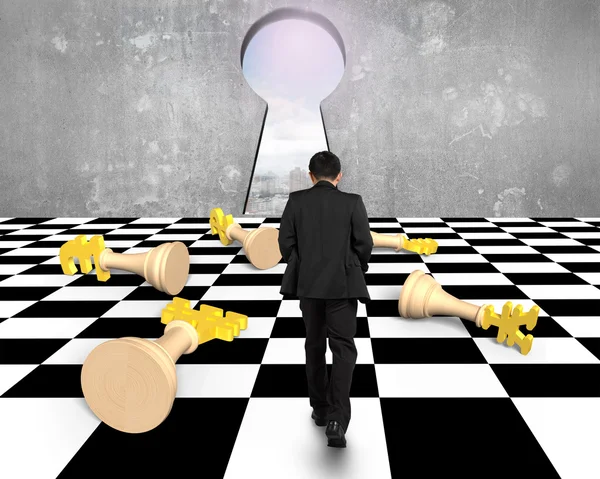 Lying money chess with businessman walking toward keyhole — Stock Photo, Image