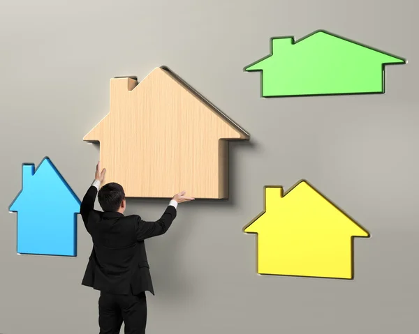 Man hands putting wooden house in suitable hole — Stock Photo, Image