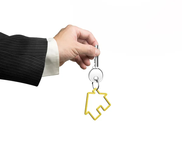 Mężczyzna ręka trzyma klucz z domu kształt keyring — Zdjęcie stockowe