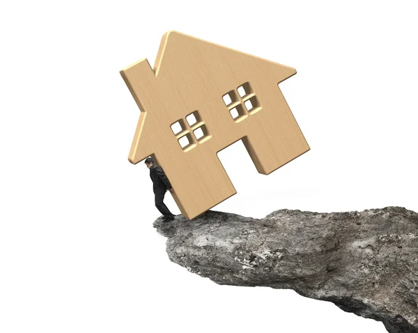 Man holding wooden house on cliff edge — Stock Photo, Image