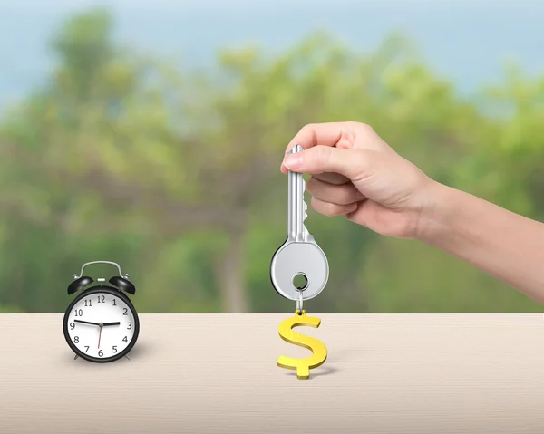Ruce drží klíč s znak dolaru klíčenky a budík — Stock fotografie