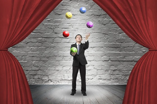 Žonglování s míčky symbol měny na červený závěs s podnikatel — Stock fotografie