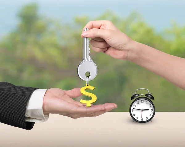 Vrouw hand geven belangrijke dollarteken keyring man hand — Stockfoto