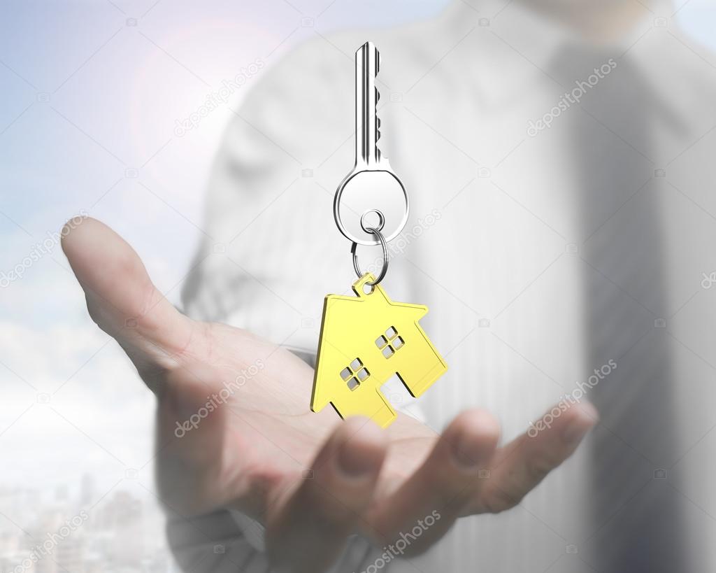 Man hand holding key with house shape keyring