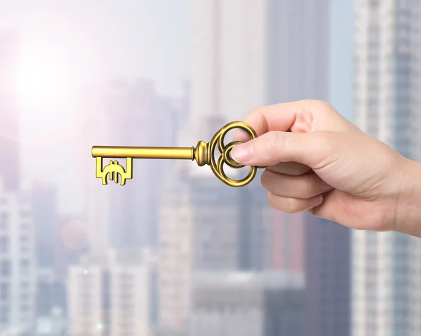 Ruka držící zlatý poklad klíč ve tvaru symbolu Euro — Stock fotografie