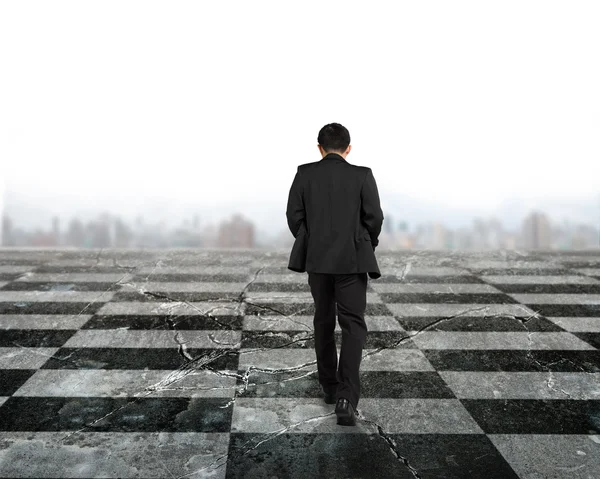 Z tyłu widok biznesmen chodzenie na szachownicy — Zdjęcie stockowe