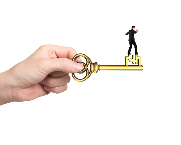 Man balance on treasure key in pound sign shape — Stock Photo, Image