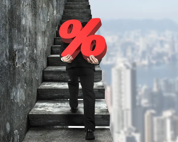 Man carrying percentage sign climbing on old concrete stairs — Stock Photo, Image