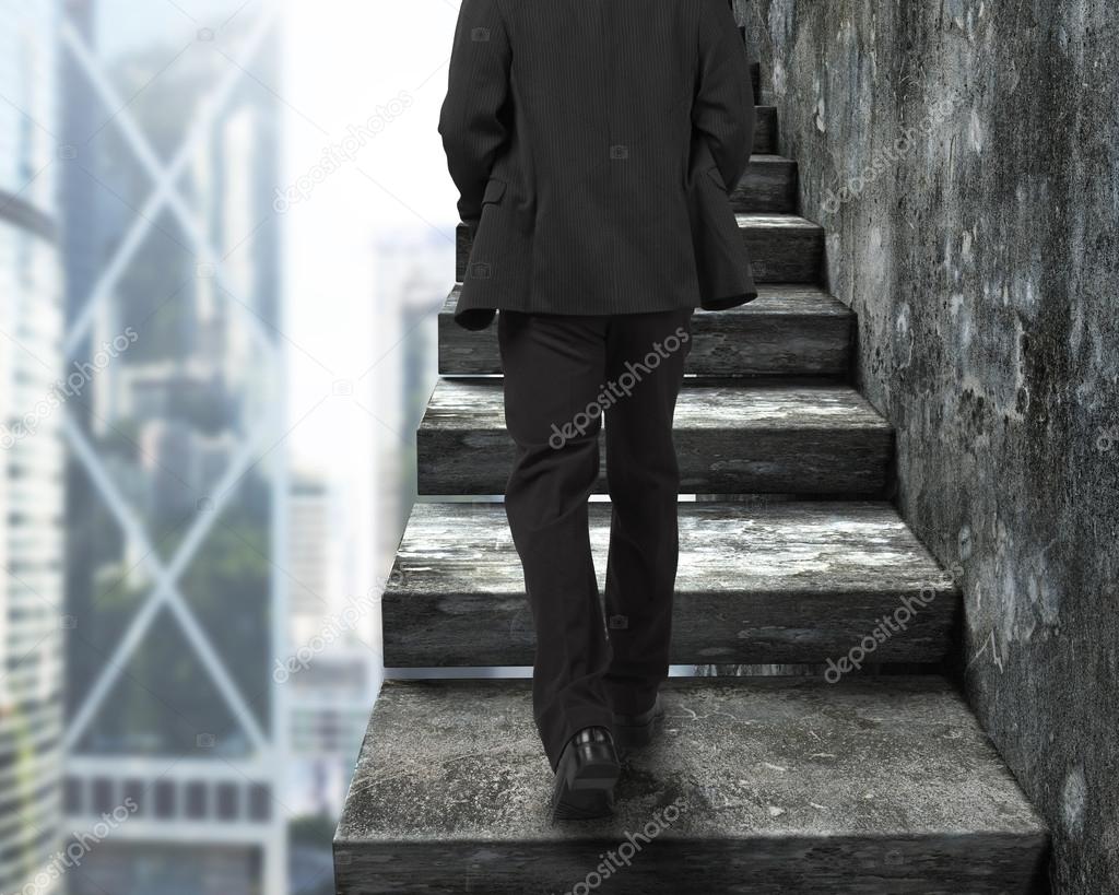 Businessman walking up the old concrete stairs