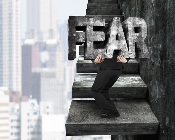 Businessman carrying fear concrete word on old concrete stairs — Stock Photo, Image