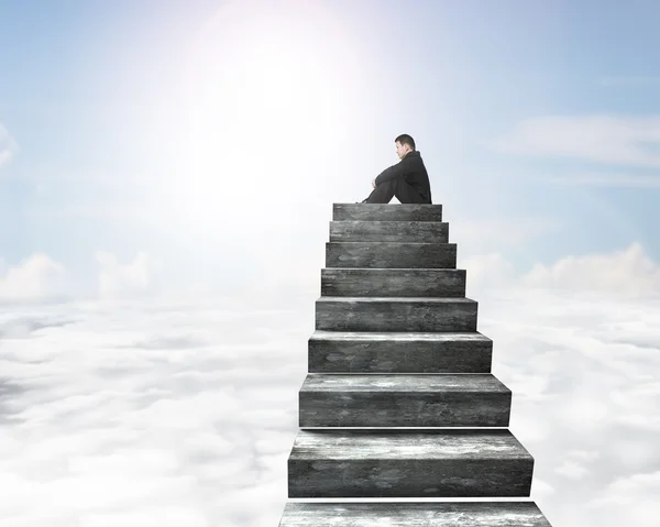Boční pohled na muže, který seděl na vrcholu betonové schodiště — Stock fotografie