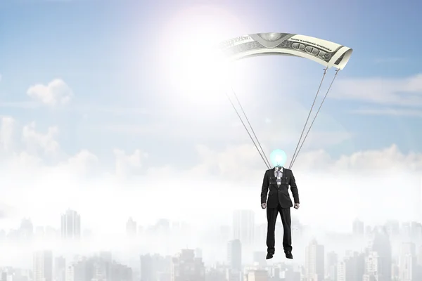 Homem com dinheiro paraquedas voando no céu — Fotografia de Stock