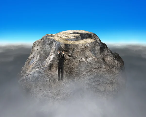 Man som försöker klättra upp rocky pengar berg — Stockfoto