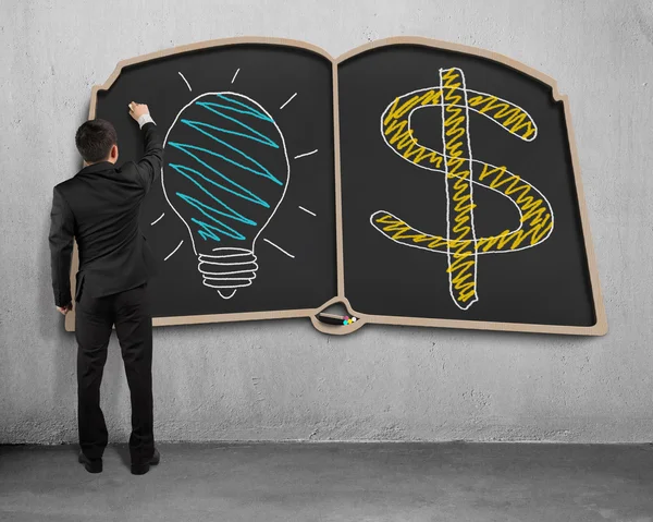 Businessman drawing on book shape blackboard — Stock Photo, Image