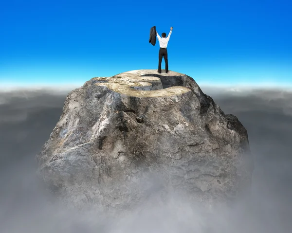 Ujjongott pénzt szimbólum sziklás hegy tetején — Stock Fotó