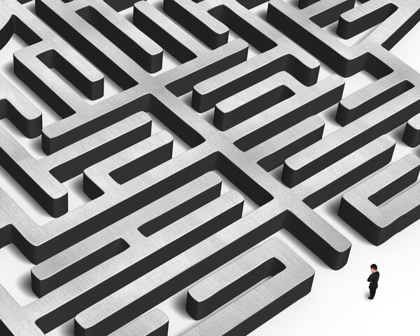 Человек стоит перед огромным бетонным лабиринтом
