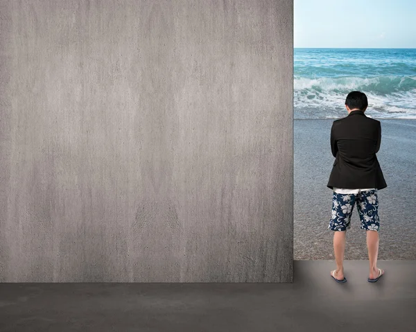 Homem de shorts pensando e de pé na entrada da praia — Fotografia de Stock