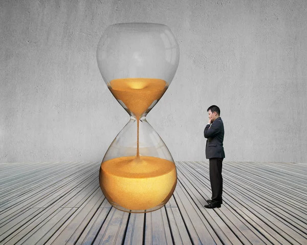 Standing manager looking the hourglass — Stock Photo, Image