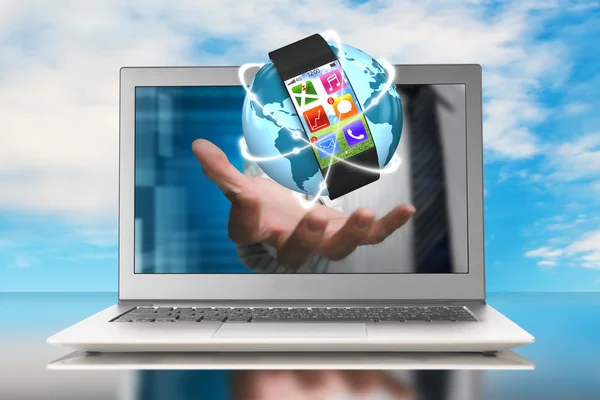 Smartwatch and glowing orbit globe in hand through laptop — Stock Photo, Image