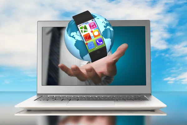 Smartwatch and globe in hand through laptop — Stock Photo, Image