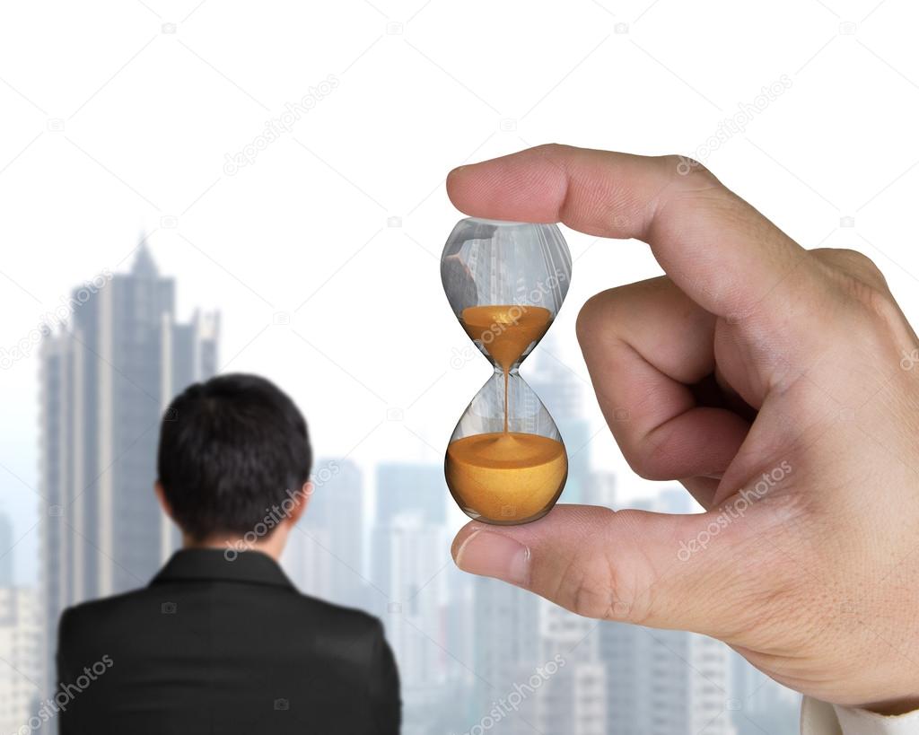 Human hand holding hourglass with businessman