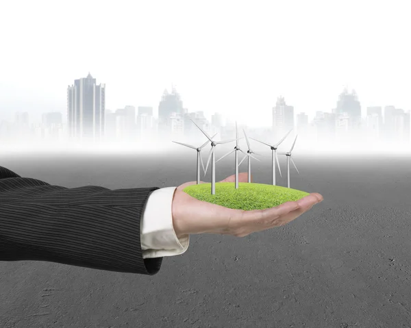 Hand holding group of windmills on grass — Stock Photo, Image