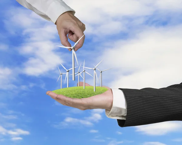 Men hands holding windturbines on meadow — Stock Photo, Image