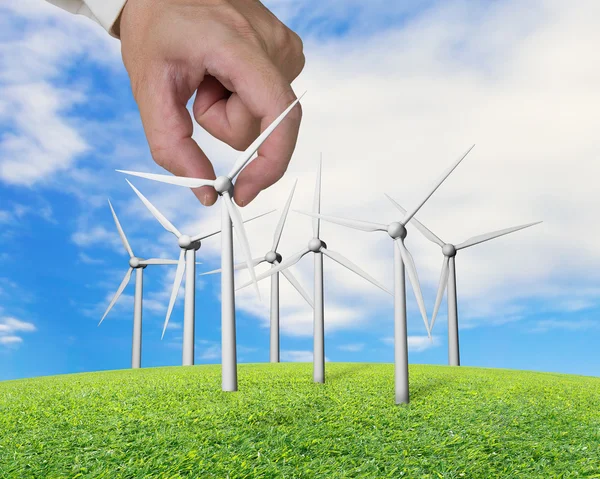 Hand holding wind turbines on grass — Stock Photo, Image