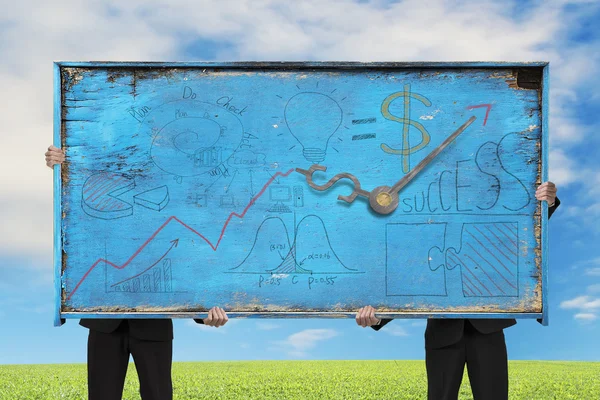 Two men holding old blue doodles billboard on nature sky — Stock Photo, Image