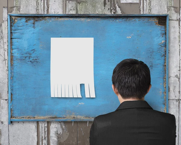 Uomo d'affari guardando carta bianca su vecchio cartellone pubblicitario — Foto Stock