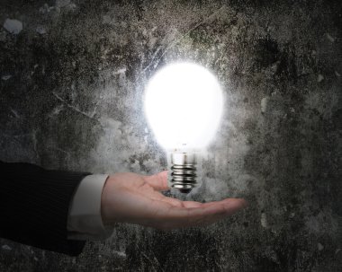 insan eli parlak ampul aydınlatmalı karanlık duvar eski holding