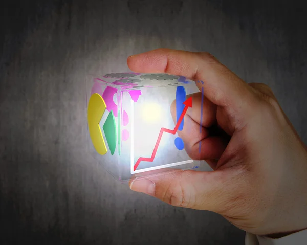 Mão segurando brilhante colorido cúbico de vidro transparente — Fotografia de Stock