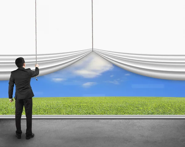 Businessman pulling open white blank curtain discovered natural — Stock Photo, Image